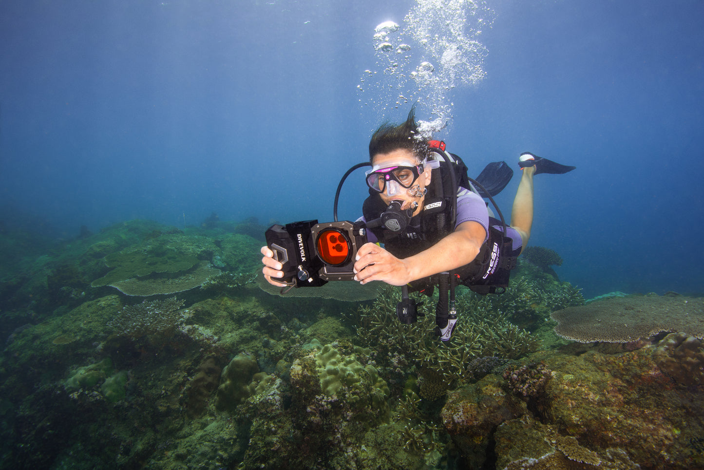 A SCUBA Diver holds their phone safe in its waterproof dive housing with the Divevolk Seatouch 4 Max Filter Kit for underwater colour correction