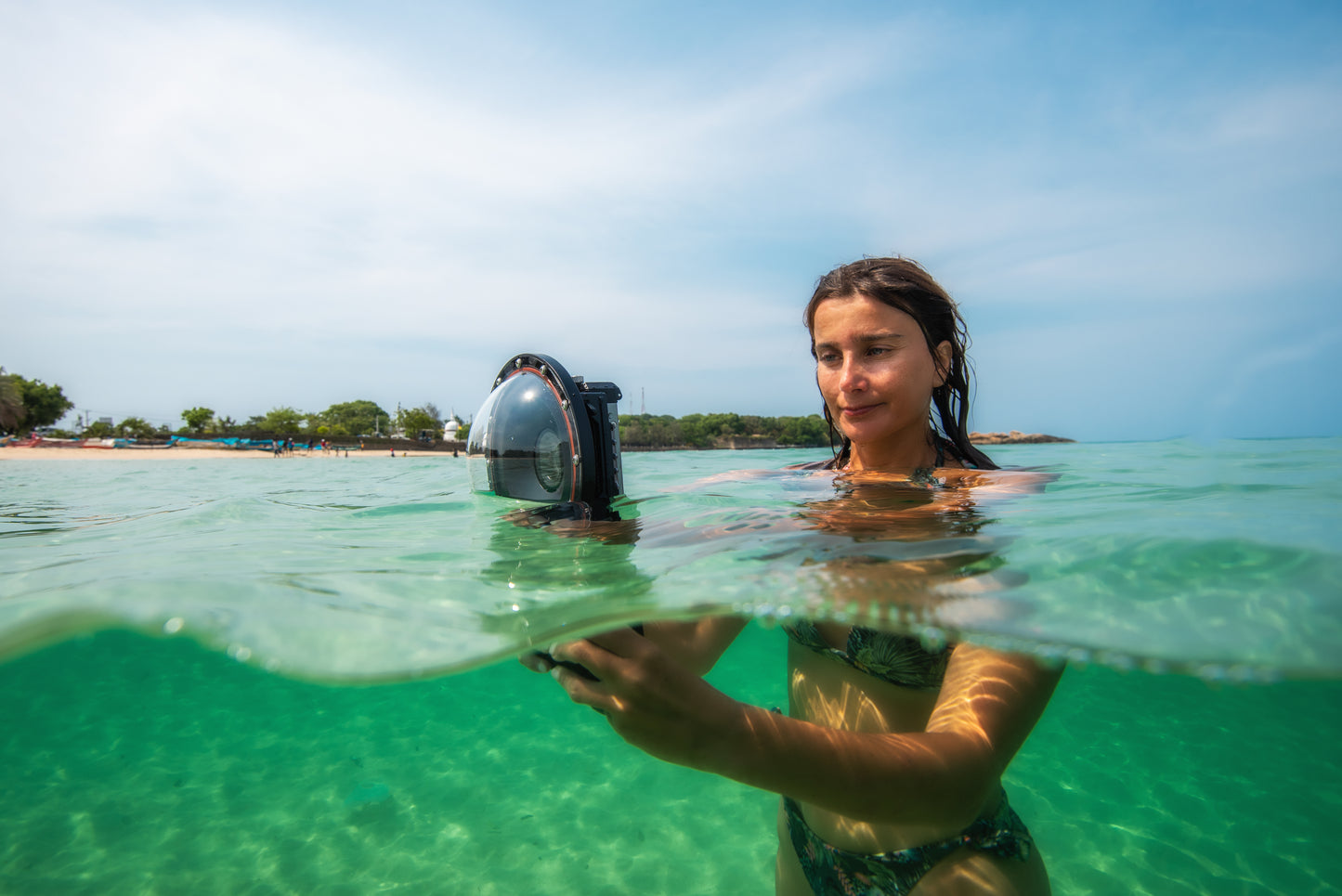 A young lady takes a split shot photo at the surface using the Divevolk Seatouch4 Max Housing and Divevolk Dome Lens