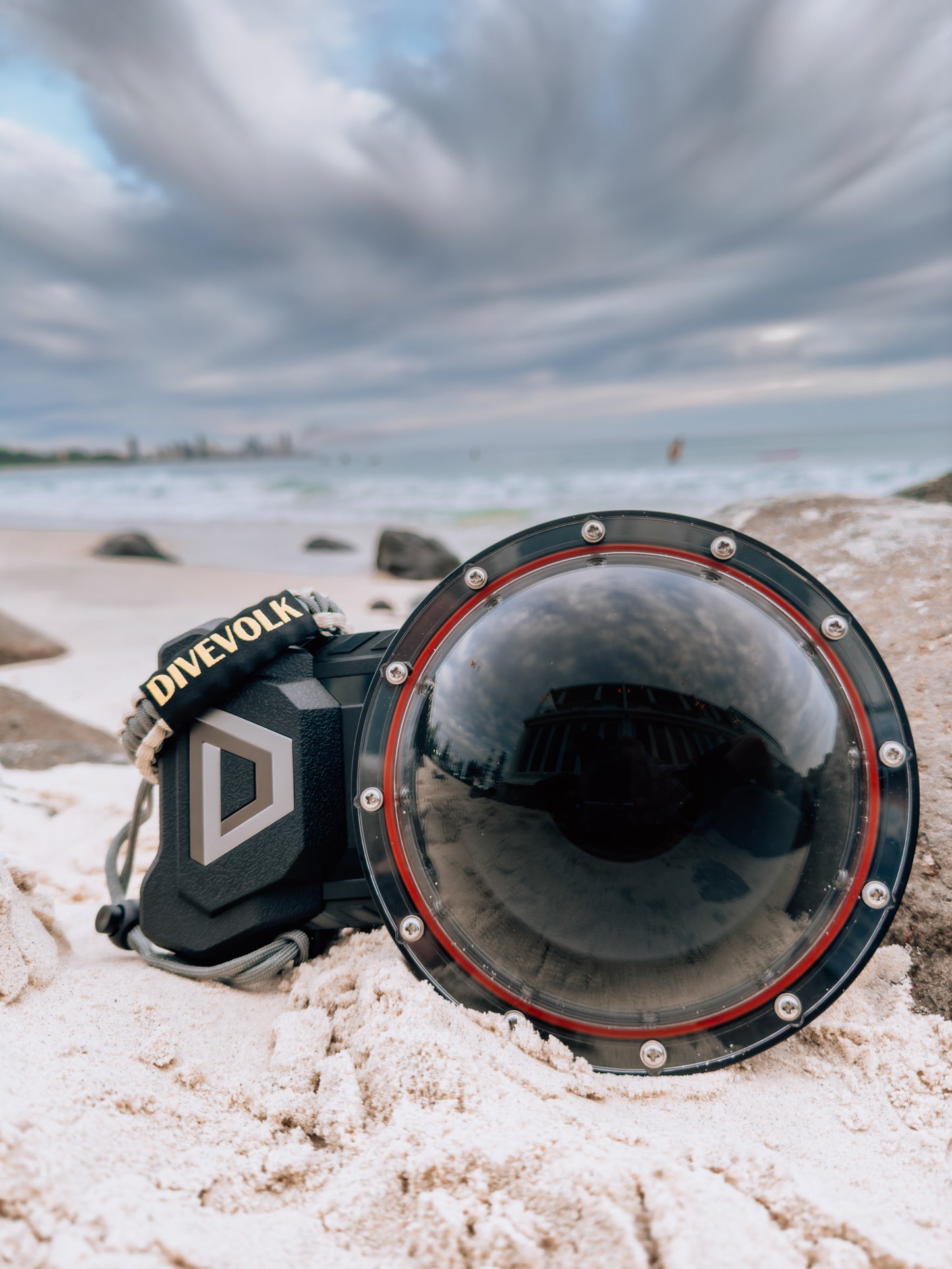 The Divevolk Seatouch 4 Max Smartphone Housing situated on the beach with the Dome lens installed