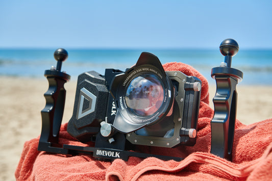 The Divevolk Seatouch4 Max Waterproof smart phone housing sits on a beach towel with the wide angle lens and dual tray installed.