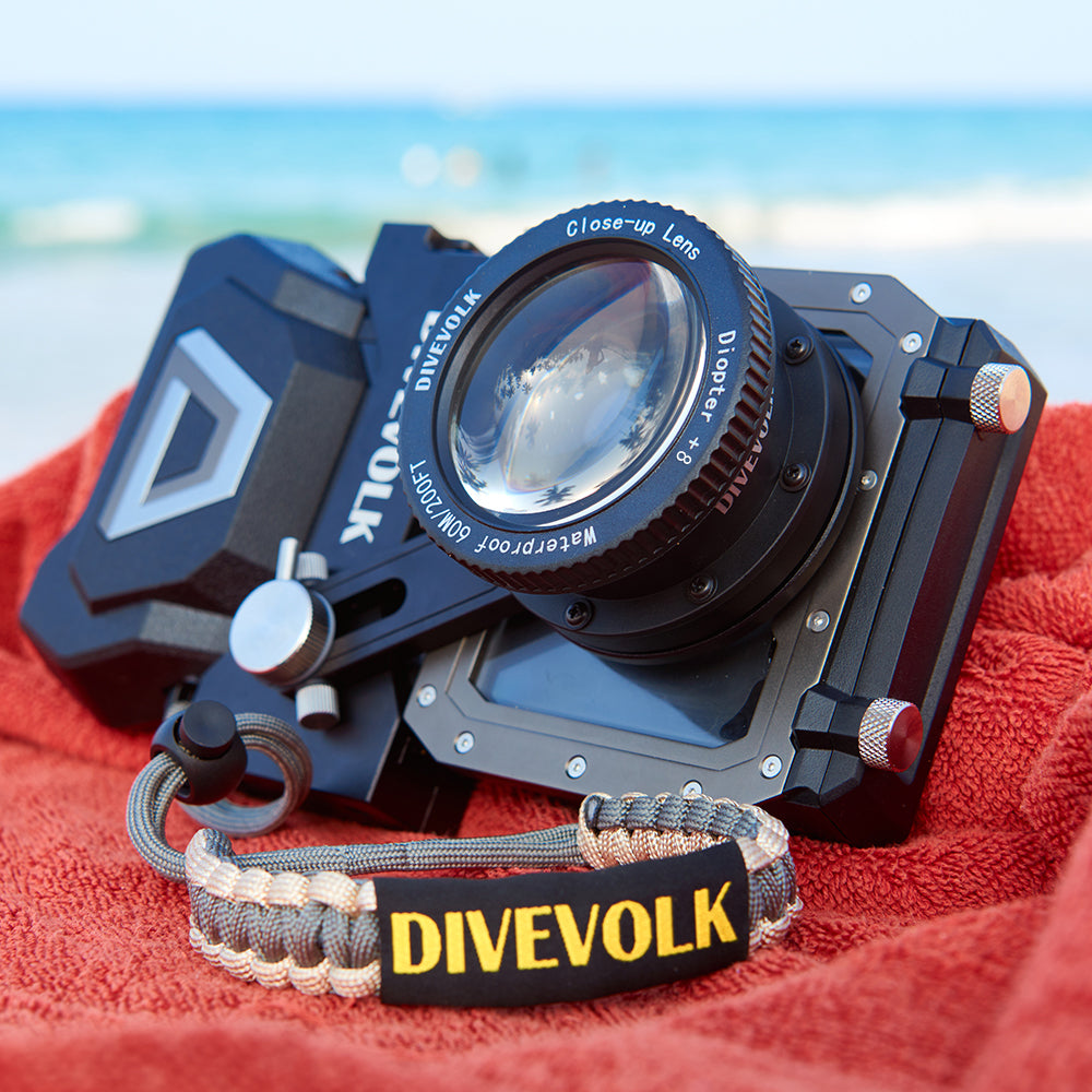 Divevolk SeaTouch 4 Max PLUS Housing and Macro Kit with 'Divevolk' branding on a red towel by the ocean