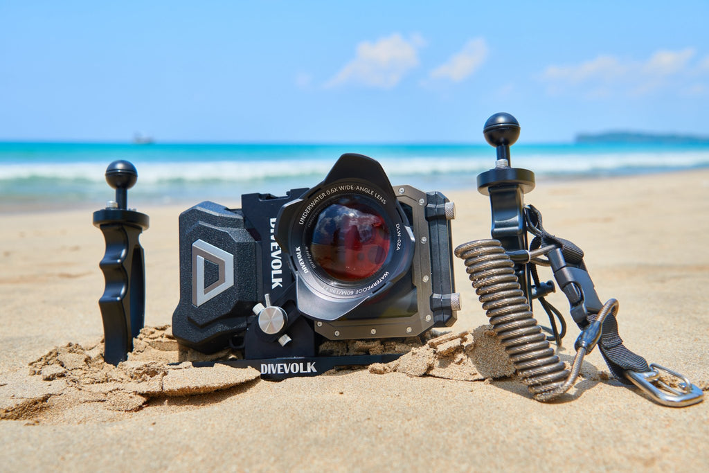 Divevolk Seatouch4 Max Housing on a sandy beach with Wide - Angle Lens, Double Tray, Red Filter, Expansion Clamp and Coil Lanyard all Installed.