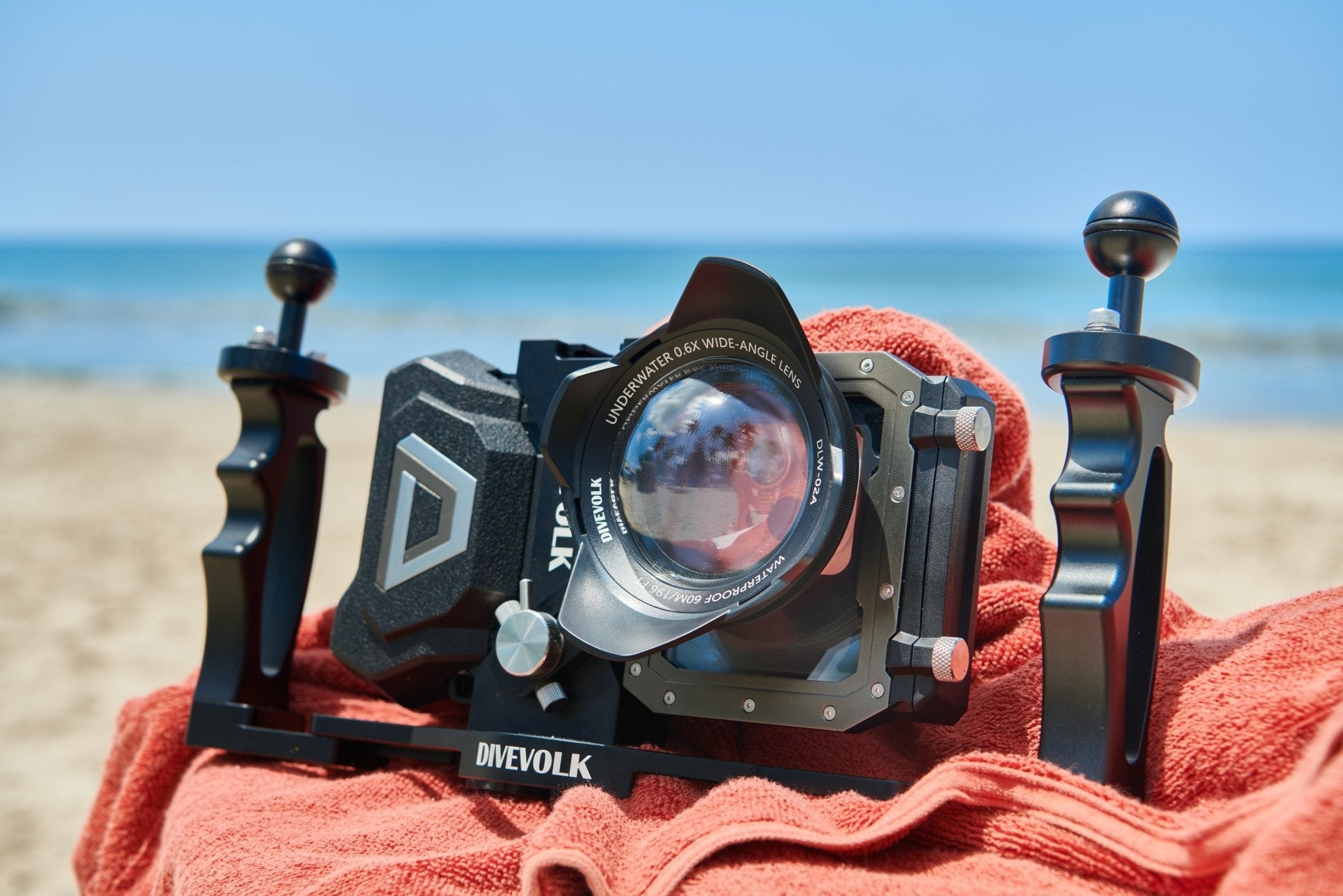 The Divevolk Seatouch4 Max Waterproof smart phone housing sits on a beach towel with the wide angle lens and dual tray installed.