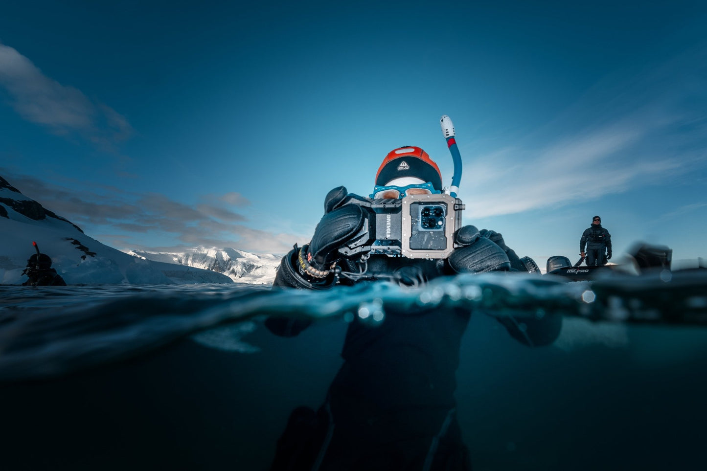A free diver in the Arctic uses the Divevolk Seatouch Surface Dome to take a split - shot photo of their buddy who is also using a Divevolk Seatouch 4 Max Waterproof phone housing
