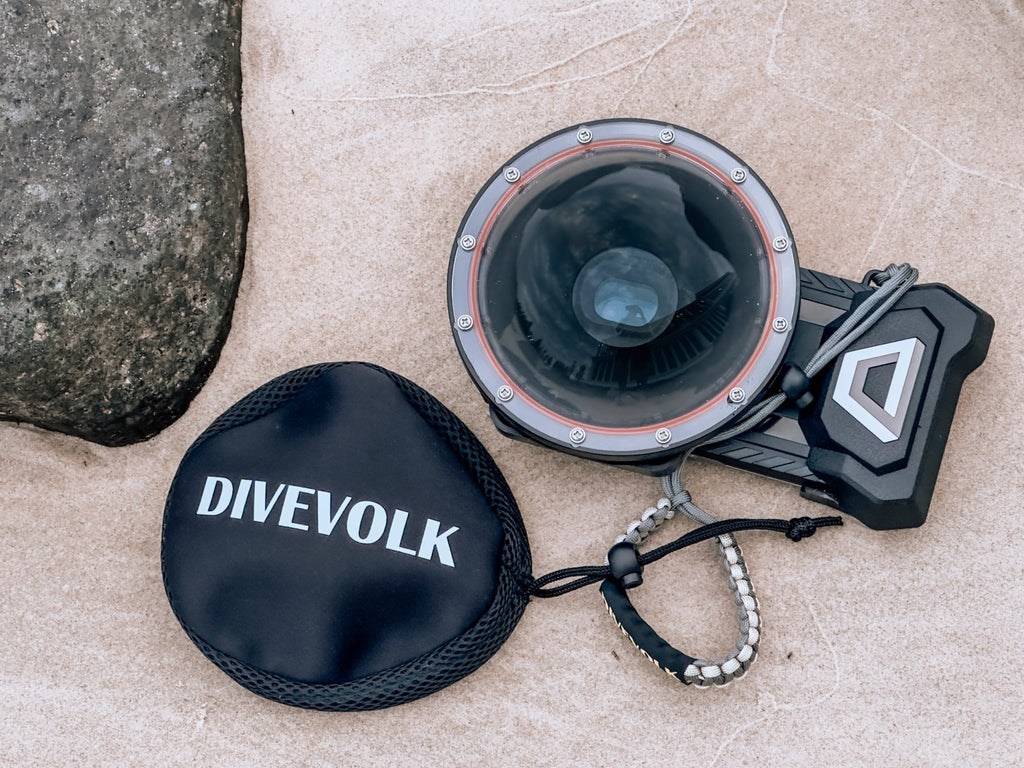 The Divevolk Seatouch 4 Max Smartphone Housing face up in the sand with the Dome lens installed
