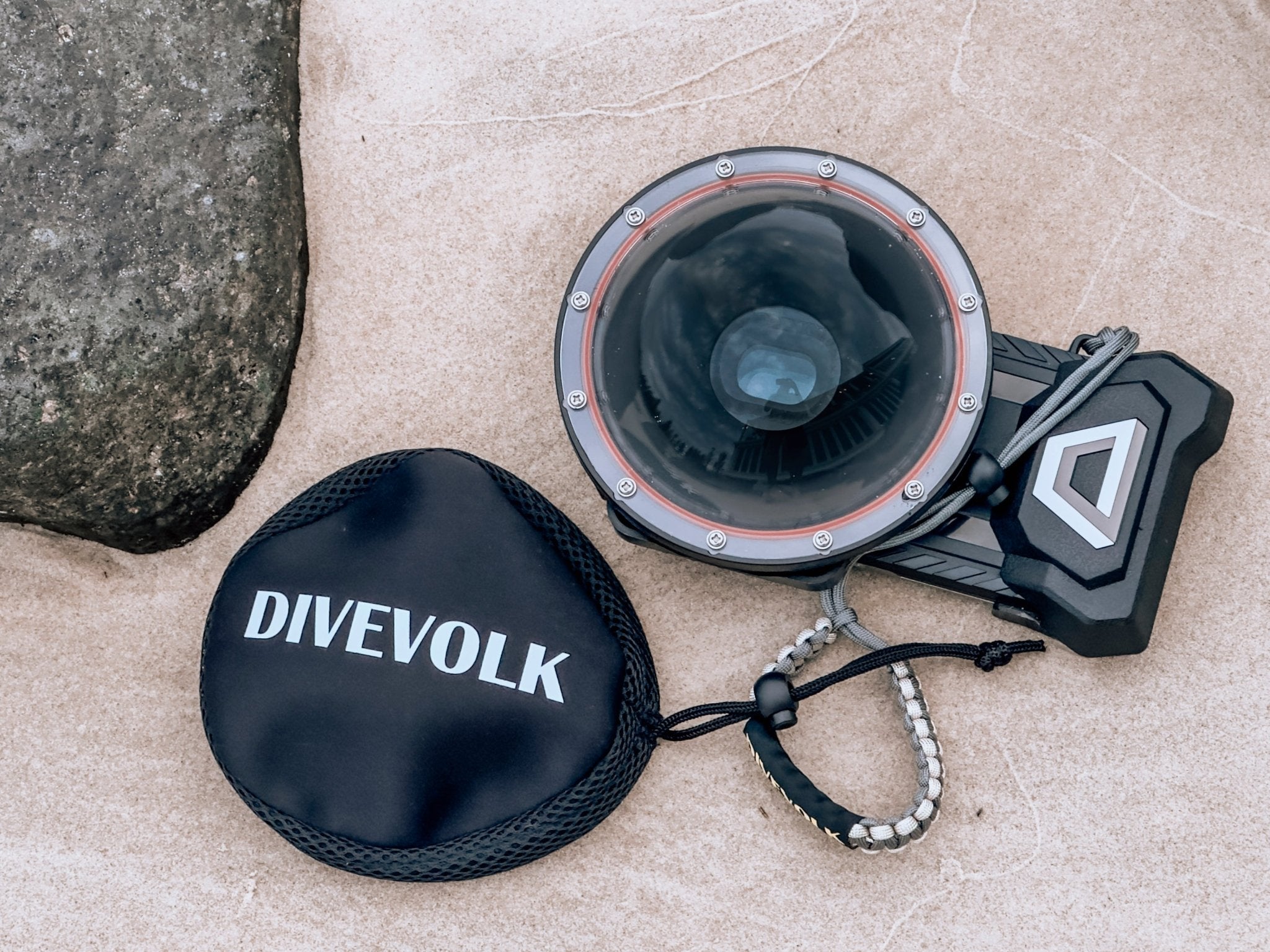 The Divevolk Seatouch 4 Max Smartphone Housing face up in the sand with the Dome lens installed